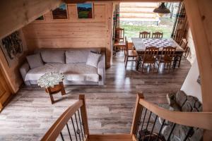 ein Wohnzimmer mit Sofa und Tisch in der Unterkunft Domki i Apartamenty Na Wyskówkach Jacuzzi & Sauna in Zakopane