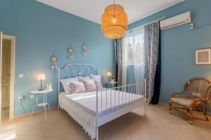 a blue bedroom with a bed and a chair at Casa Di Porto Roma in Vasilikos