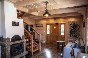 ein Wohnzimmer mit Kamin in einer Blockhütte in der Unterkunft Domki i Apartamenty Na Wyskówkach Jacuzzi & Sauna in Zakopane