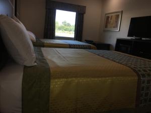 a bed in a hotel room with a window at Americas Best Value lnn- Plaquemine in Plaquemine