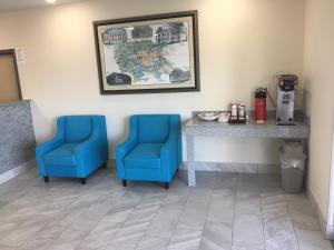 two blue chairs and a table in a room at Americas Best Value lnn- Plaquemine in Plaquemine