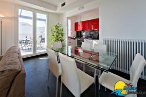 レウカにあるSH-Salento Luxury Apartment Giuseppeのダイニングルーム(ガラステーブル、白い椅子付)