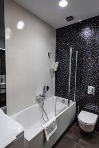 a bathroom with a tub and a toilet and a shower at Parliament on Rustaveli Studio in Tbilisi City +28 photos