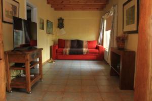 ein Wohnzimmer mit einem roten Sofa und einem TV in der Unterkunft Departamento Costanera in San Carlos de Bariloche