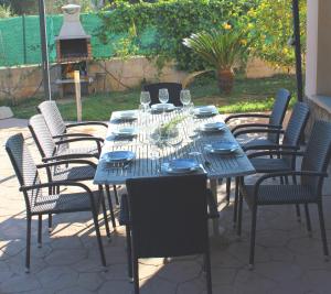 a blue table with chairs and wine glasses at Aina in Cala Pi