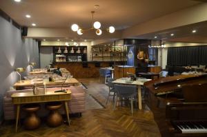 a restaurant with tables and chairs and a piano at Parliament on Rustaveli Studio in Tbilisi City