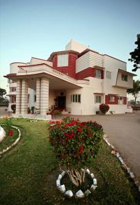 una casa grande con un arbusto delante de ella en Karni Bhawan Palace - Heritageby HRH Group of Hotels, en Bikaner