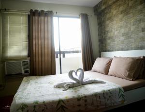 a bed with a towel with a heart on it at Apartelle D' Oasis in Davao City +69 photos
