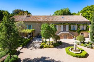 an old stone house with a garden in front of it at Moulin de Vaucroze in Sorgues