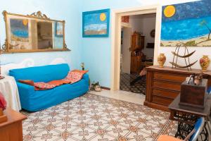 a living room with a blue couch and a dresser at B&B Favignana in Favignana