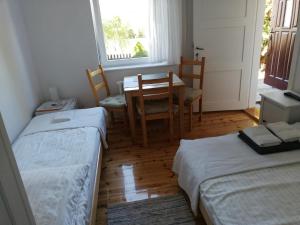 a room with two beds and a table and chairs at Kwatery u Eve in Dziwnów
