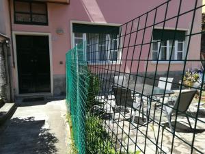 une maison rose avec une table et une clôture dans l'établissement CASA DELLE ARANCE, à Monterosso al Mare