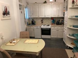 a kitchen with white cabinets and a table at Apartment Pein 5 in Loutraki