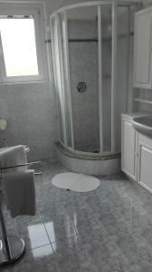 uma casa de banho com um chuveiro e um lavatório. em Panorama sul lago em Porto Valtravaglia