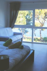 a bedroom with two beds and a large window at Casa Xisca in Cala Pi