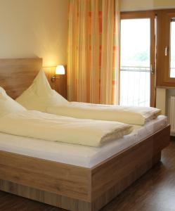 two beds in a room with a large window at Gasthof Zum Schwanen in Kleinostheim