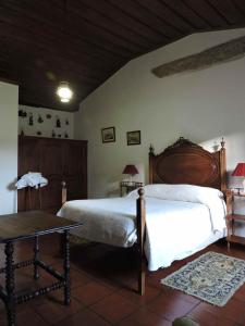 1 dormitorio con 1 cama grande y 1 mesa en Quarto das Lamparinas, en Ponte de Lima