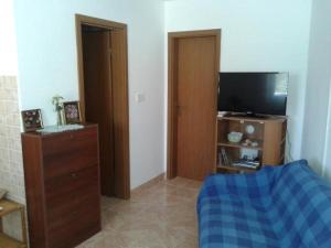 een woonkamer met een tv en een dressoir met een dressoir bij Apartmani Belajec in Dramalj
