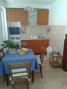 een keuken met een tafel en een fruitschaal bij Apartmani Belajec in Dramalj