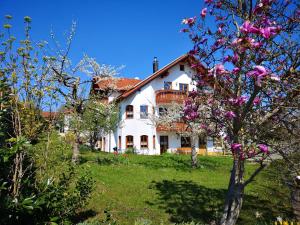 een wit huis op een heuvel met roze bloemen bij 70m²- Ferienwohnung mit Terrasse in Achberg