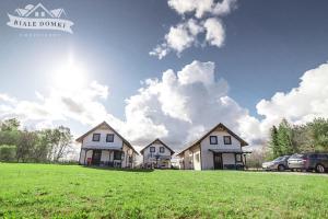 un grupo de casas en un campo verde en Białe Domki Mrzeżyno en Mrzeżyno