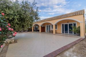 a house with a large patio in front of it at Casa Di Porto Roma in Vasilikos
