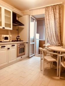 a kitchen with a table and a dining room at Classic Apartment in Boryspil