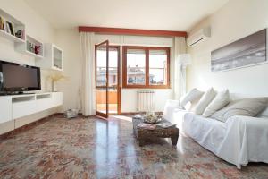 a living room with a white couch and a tv at ANAGNINO WHITE HOME in Rome