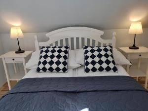 a bedroom with a bed with black and white pillows at Ranczo w Dolinie Karpia - blisko "Energylandii" Zator in Spytkowice