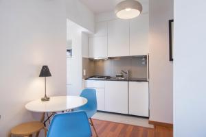 a kitchen with white cabinets and a table and chairs at The Castle Life in 3BDR apartament in Lisbon