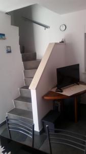 a desk with a computer on it next to a staircase at Holiday Home White House in Sumartin