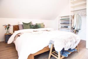 ein Schlafzimmer mit einem weißen Bett und einer weißen Bettdecke in der Unterkunft Fewo-TS / Das Loft zum Wohlfühlen in Traunstein