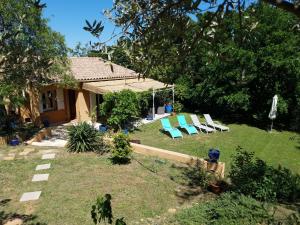 a yard with lounge chairs and a house at Entre Nîmes et Arles in Bellegarde