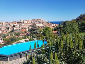 a view of a resort with a swimming pool and a city at Villa Caterina in Imperia
