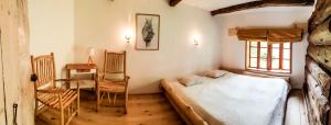 a bedroom with a bed and a table and a chair at Dzikie Roztocze - Stara Chata in Krasnobród