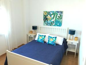 a bedroom with a bed with blue sheets and pillows at Beautiful penthouse with ocean and marina views in Isla Canela +12 photos