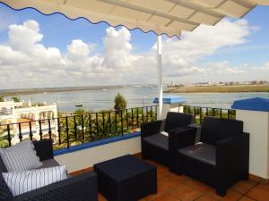 a balcony with chairs and a view of the water at Beautiful penthouse with ocean and marina views in Isla Canela