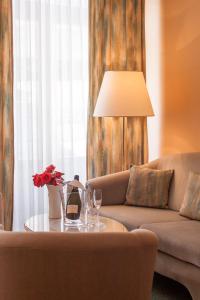 a living room with a couch and a table with wine glasses at Hotel Villa Auguste Viktoria in Ahlbeck