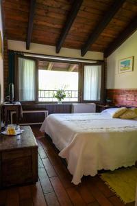 1 dormitorio con 1 cama blanca grande y ventanas en Agriturismo La Garzonera, en Vergiate
