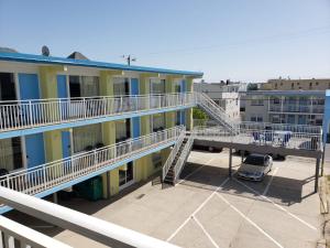 un edificio de apartamentos con balcón y aparcamiento en Tropicana Motel, en Wildwood