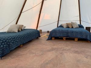 two beds in a room with a yurt at Bosque de Aventura & Glamping El Faro in La Mesa +104 photos