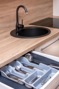 a sink in a kitchen with silver utensils at Apartment Amber Wind in Palanga
