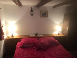 1 dormitorio con 1 cama con sábanas rojas y 2 lámparas en Holiday home Hižica v plavem trnacu, en Gornja Stubica