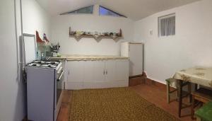 a small kitchen with a stove and a refrigerator at Pensiunea Panorama in Băile Tuşnad