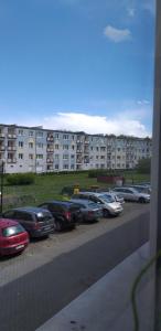 a row of cars parked in a parking lot in front of a building at Apartament Pomorski in Hel