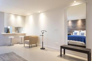 ein Schlafzimmer mit einem Bett, einem Tisch und einem Stuhl in der Unterkunft Rooms & Suites Loft 2H Deluxe Edition Arrecife in Arrecife