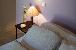 a bedroom with a bed and a table with a lamp at Le Bouquet de l Aromate in Joucas