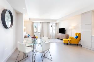 ein Wohnzimmer mit einem Glastisch und Stühlen in der Unterkunft Rooms & Suites Loft 2H Deluxe Edition Arrecife in Arrecife