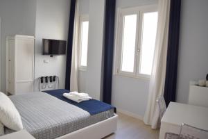 une chambre blanche avec un lit et une fenêtre dans l'établissement B&B OndeChic, à Cagliari