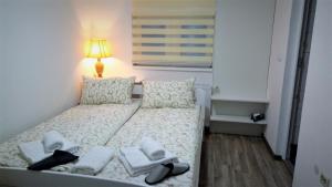 Un dormitorio con una cama con zapatos y una lámpara. en Apartments&Rooms Mido, en Visoko